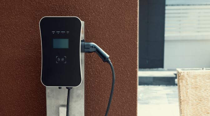 Progressive green energy-powered charging station concept for electric vehicle connected to home charging station at the garage or backyard. Eco friendly rechargeable car powered by clean energy.